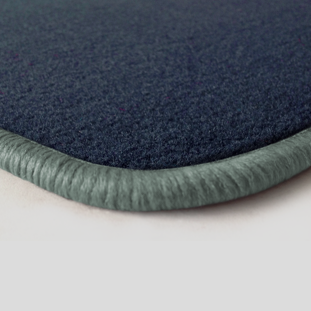 Eine Ecke als Beispiel einer Fussmatte Velours dunkelblau mit Rand in silbergrau.